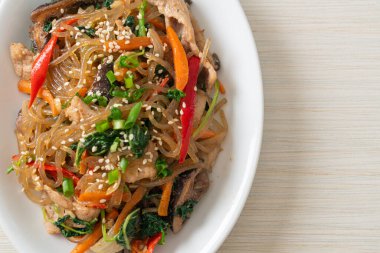 Japchae ya da karışık Kore vermicelli erişte sebzeli ve üzerine beyaz susamlı domuz eti - Kore geleneksel yemek tarzı