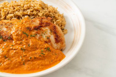 Kırmızı köri soslu ızgara tavuk bifteği ve pilav. Müslüman usulü.