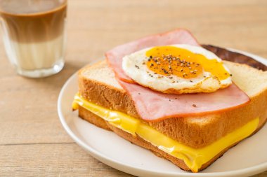 Ev yapımı ekmek üzerine kızarmış peynir jambon ve kızarmış yumurta ile domuz sosisi ve kahvaltıda kahve.