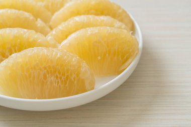 Taze soyulmuş zeytin, greyfurt ya da beyaz tabakta Shaddock.