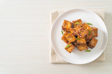 Beyaz susamlı kızarmış tofu ve teriyaki sosu. Vejetaryen ve vejetaryen yemek tarzı.