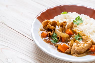 Dilimlenmiş domuz eti, havuç ve soğanlı Japon körili pilavı. Asya usulü.