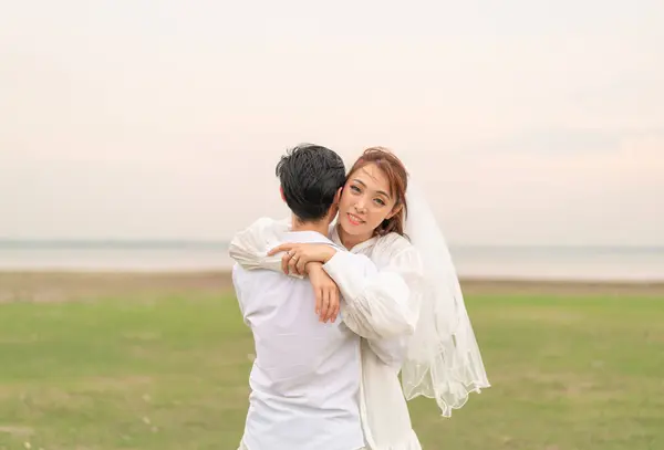 結婚式や結婚式のお祝いの準備ができて花嫁と新郎の服で幸せな若いアジアのカップル — ストック写真