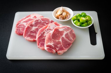 Taze domuz boyunlu ya da yakalı domuz eti ve terbiye edilecek malzemeler.