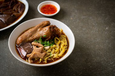 Kahverengi çorbada haşlanmış ördek ve haşlanmış yumurtalı şehriye Asya yemeği.