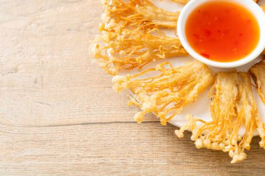 Kızarmış enoki mantarı ya da baharatlı soslu altın iğneli mantar - vejetaryen yemek tarzı.