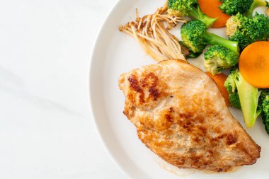 Beyaz tabakta sebzeli ızgara tavuk bifteği