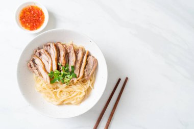 Beyaz kasede pişmiş ördekle kurutulmuş şehriye. Asya usulü.