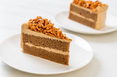 Ev yapımı kahve badem keki beyaz tabakta.