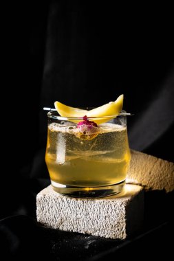 Kokteyl - burbon, ev yapımı turşu mango ve yıldız üzümü, portakal suyu, kıvılcım şarabı, koyu arkaplanda limon suyu.