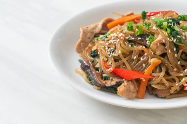 Japchae ya da karışık Kore vermicelli erişte sebzeli ve üzerine beyaz susamlı domuz eti - Kore geleneksel yemek tarzı