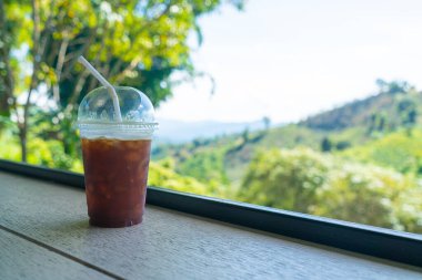 Dağ tepesi arka planında buzlu sade kahve.