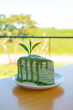 Beyaz tabakta kibrit yeşil çay krepi keki