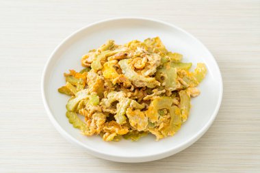 Kızarmış acı kabağı tabakta yumurta ile karıştır