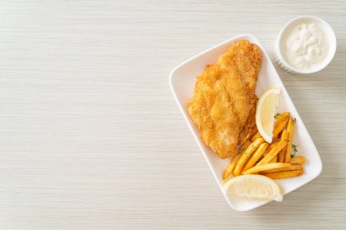 balık ve patates kızartması - kızarmış balık fileto patates cipsi ve limonlu beyaz tabak