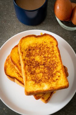 Kahvaltı için beyaz tabakta yumurtalı ekmek.