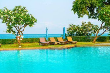 Havuz kenarındaki havuz, havuz, şemsiye, deniz manzaralı havuz tatilleri ve tatil konsepti.