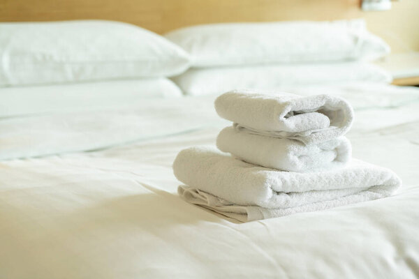 close-up white towel stack on bed