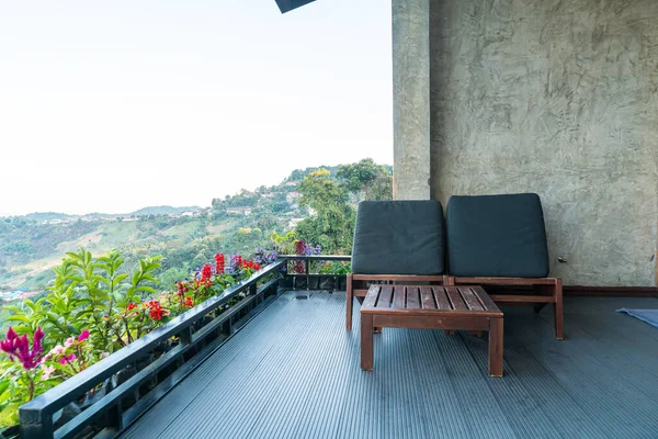 empty chair on balcony with mountain hill background
