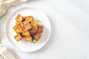 Beyaz susamlı kızarmış tofu ve teriyaki sosu. Vejetaryen ve vejetaryen yemek tarzı.