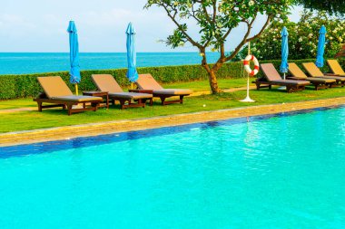 Havuz kenarındaki havuz, havuz, şemsiye, deniz manzaralı havuz tatilleri ve tatil konsepti.