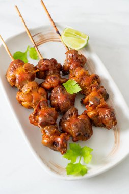 Izgara tavuk şişi. Tabakta baharat ve şifalı otlar var.