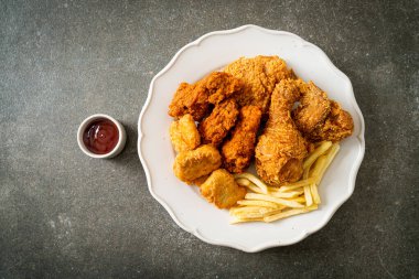 Patates kızartmalı kızarmış tavuk ve tabakta nugget - sağlıksız yemek.