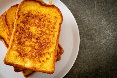 Kahvaltı için beyaz tabakta yumurtalı ekmek.