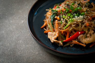 Japchae ya da karışık Kore vermicelli erişte sebzeli ve üzerine beyaz susamlı domuz eti - Kore geleneksel yemek tarzı