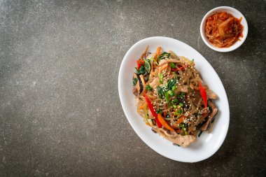 Japchae ya da karışık Kore vermicelli erişte sebzeli ve üzerine beyaz susamlı domuz eti - Kore geleneksel yemek tarzı