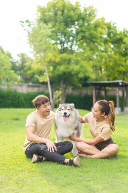 Asian couple love with cute dog in garden