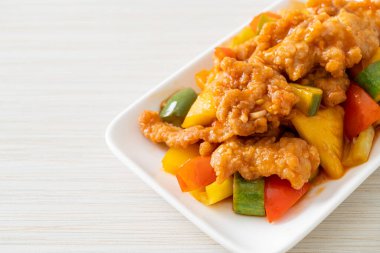 Kızarmış tatlı ve ekşi sosla domuz ve sebzeyi karıştır.