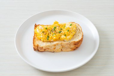 Ekmek tostu, çırpılmış yumurta ve beyaz tabak.