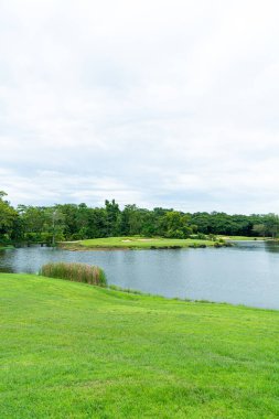 Green and Sand bunkers on Golf course with mountain hill background
