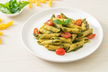 Pesto soslu ve domatesli makarna. Vejetaryen ve vejetaryen yemek tarzı.