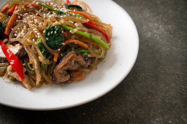 Japchae ya da karışık Kore vermicelli erişte sebzeli ve üzerine beyaz susamlı domuz eti - Kore geleneksel yemek tarzı