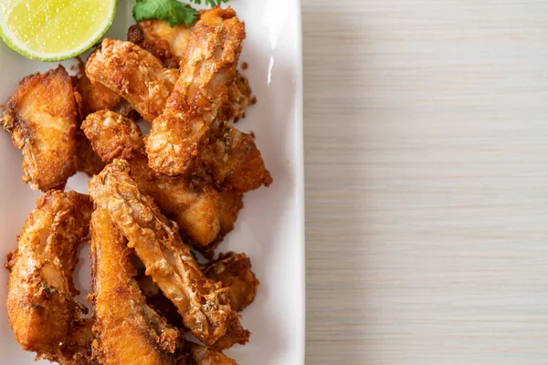 Fried Snapper Belly on white plate - Asian food style