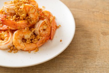 Kızarmış karides ya da beyaz tabakta sarımsaklı karides - deniz ürünleri tarzı.