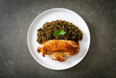 Kızarmış pesto pilavı ve beyaz tabakta kızarmış tavuk.
