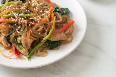 Japchae ya da karışık Kore vermicelli erişte sebzeli ve üzerine beyaz susamlı domuz eti - Kore geleneksel yemek tarzı