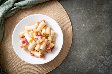 Beyaz soslu ve pastırmalı ev yapımı spagetti rigatoni makarna. İtalyan usulü.