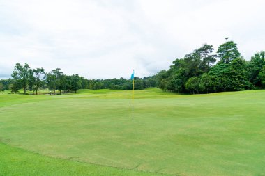 Green and Sand bunkers on Golf course with mountain hill background