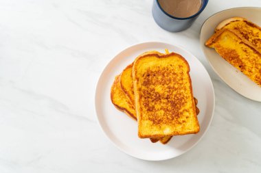 Kahvaltı için beyaz tabakta yumurtalı ekmek.