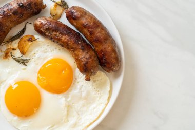 Kahvaltıda omlet ve kızarmış domuz sosisi.