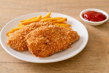 Kızarmış tavuk göğsü fileto biftek yanında patates kızartması ve ketçap.