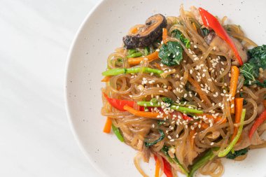 Japchae ya da karışık Kore vermicelli erişte sebzeli ve üzerine beyaz susamlı domuz eti - Kore geleneksel yemek tarzı