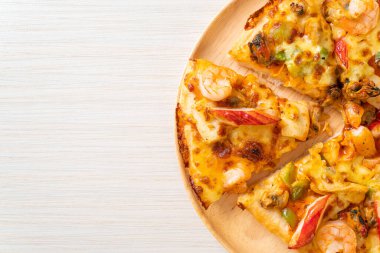 Tahta tepside deniz ürünleri (karides, ahtapot, midye ve yengeç) pizza