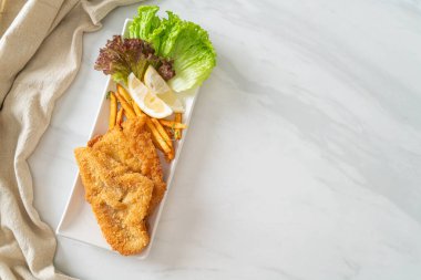 balık ve patates kızartması - kızarmış balık fileto patates cipsi ve limonlu beyaz tabak