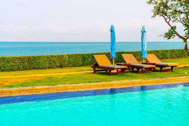 Havuz kenarındaki havuz, havuz, şemsiye, deniz manzaralı havuz tatilleri ve tatil konsepti.