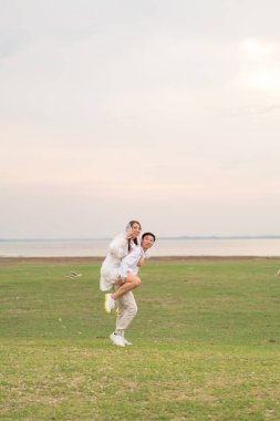 Gelin ve damat kıyafetli mutlu genç Asyalı çift evlenmeye ve evlenmeye hazır.